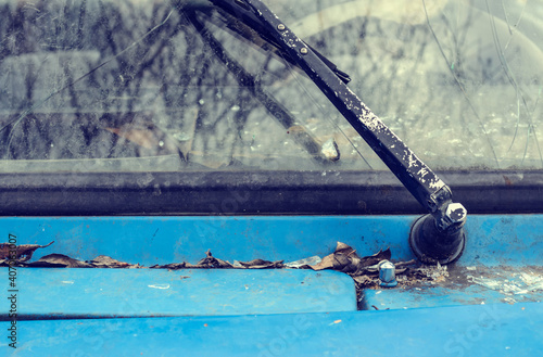 Windshield wiper old broken car, fallen leaves on it
