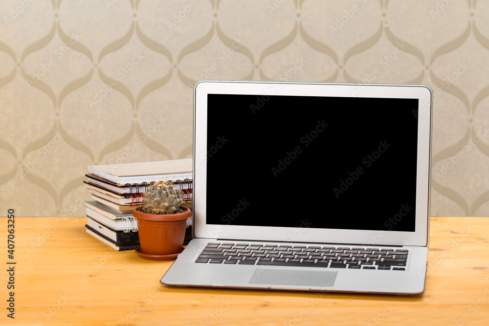 Fototapeta premium Notebook with notebooks and green succulent on a wooden table. mockup for text