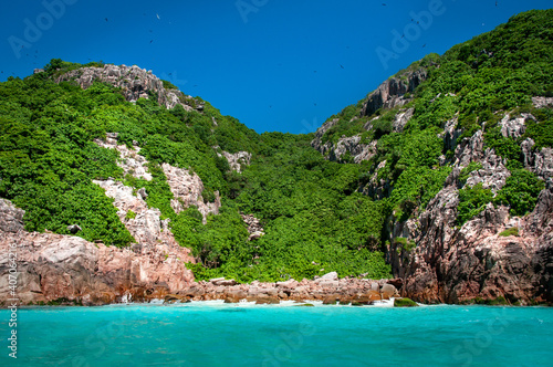 Aride island nature reserve view from the Indian Ocean with blue sky. Praslin, Seychelles