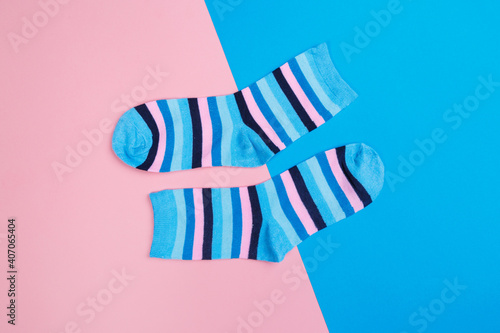 multicolored jersey socks on a pastel pink and blue background. view from above