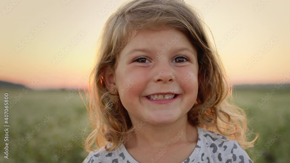 Portrait Of Little Girl On Background Of Sky And Field. Pretty Girl With Long Curly Hair. Portrait Of Little Girl On Background Of Sky And Field. Pretty Girl With Long Curly Hair.