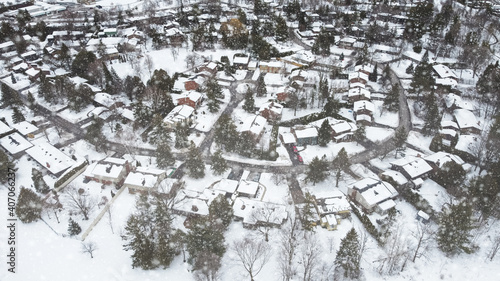Aerial top view of a winding foot path in winter , surrounded by snow. Kanata neighborhood can be seen in the background. Ottawa, Ontario, Canada © jpbarcelos
