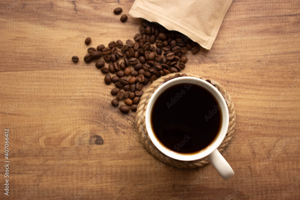 for coffee shop background. coffee in mug and coffee beans on wooden table. copy for your text. selective focus.