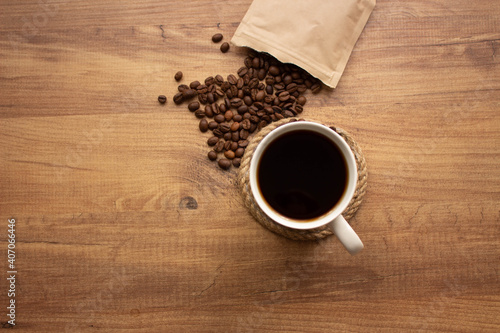coffee beans and cup of coffee on wooden table, selective focus. copy space for your text, top view.