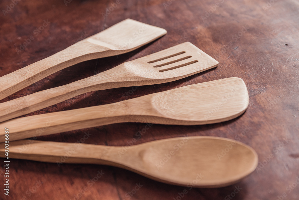 Detail photo of bamboo kitchen utensils and shovels arranged in a half moon, on a wooden background. Detail photo of bamboo kitchen utensils and shovels arranged in a half moon, on a wooden background.