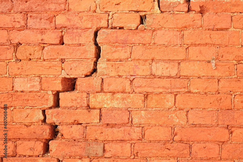Fototapeta premium Cracked Red Brick Wall With Big Crack Structure. Damaged Brickwork Surface Texture. Destroyed And Aged Old Bricklaying Rift Material.