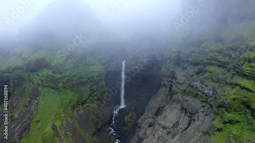 Drone footage of Hangandifoss waterfall in Mulagljufur canyon, with foggy cloudy conditions in Iceland photo