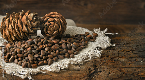 pine nuts lie on a linen cloth, pine nuts lie on an old wooden board on the back side view