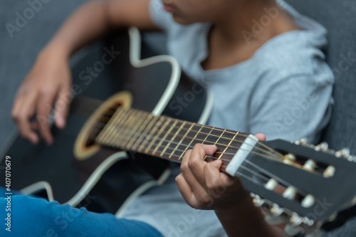 mexican boy playing the guitar at home, home schooling