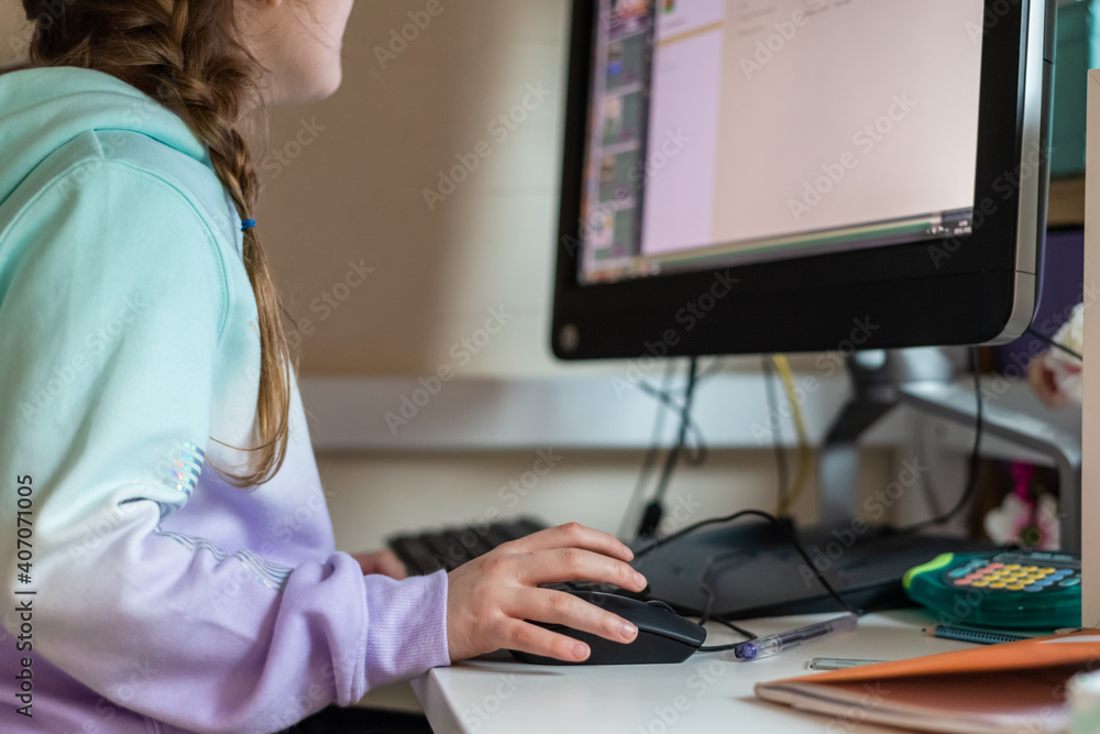 Child using a computer at home to do school work in a bedroom during school closures due to covid-19 pandemic Child using a computer at home to do school work in a bedroom during school closures due to covid-19 pandemic