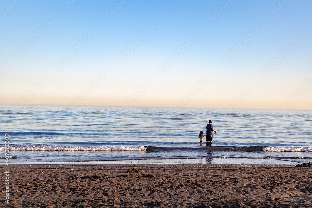 Padre con su hijo pescando en la playa en un dia soleado