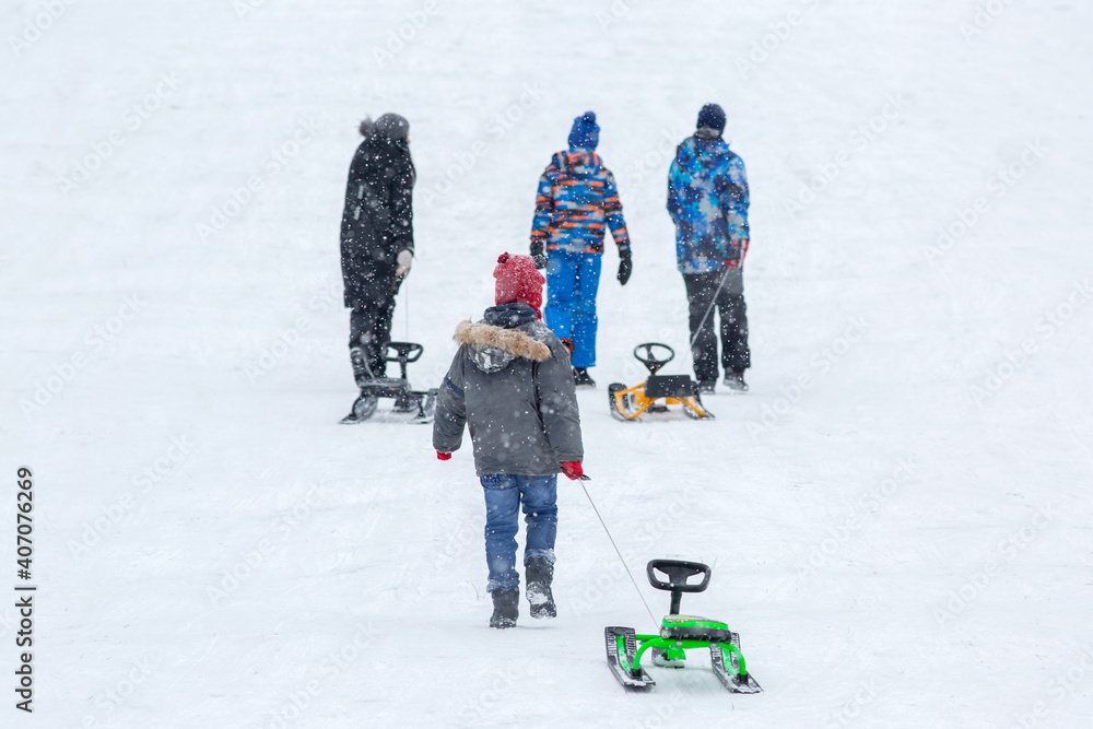 Children carry sledges up the mountain.