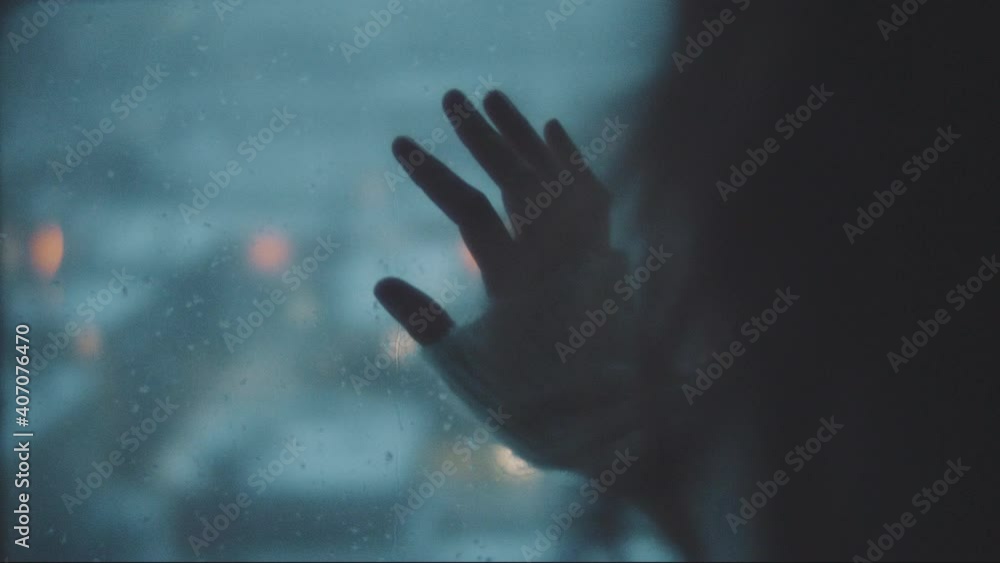 Hand of a woman touching a window Hand of a woman touching a window