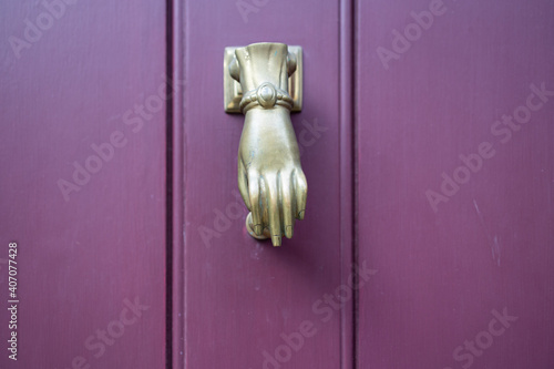 Hand door knocker and purple door