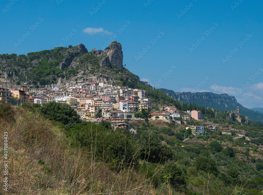Cityscape of old pictoresque village Ulassai with limestone climbing rock and green vegetation and mountains at countryside of Sardinia island. Summer sunny day. Province Nuoro, Sardinia, Italy