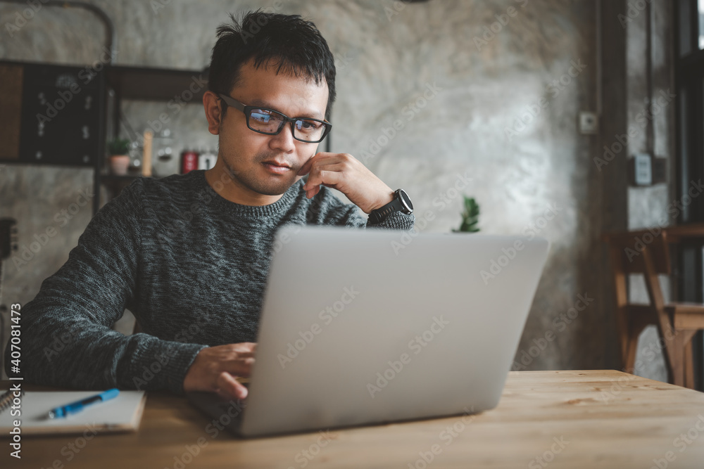 smart Asian man working with computer laptop. concept work form home, stay at home. freelance life style, New normal social distancing lifestyle smart Asian man working with computer laptop. concept work form home, stay at home. freelance life style, New normal social distancing lifestyle
