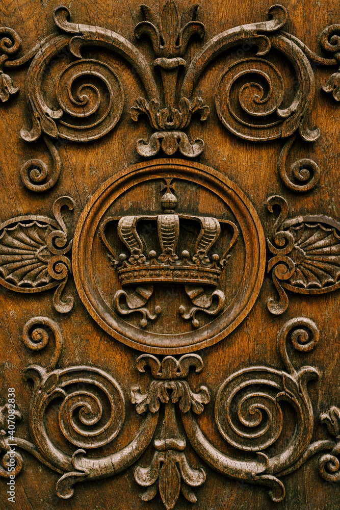 Close-up of carvings in wood - crown and curls.