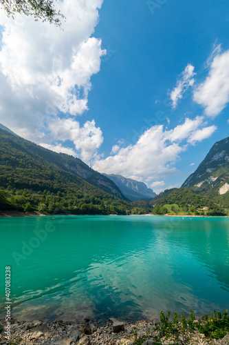 Cavedine Lake. Panorama of the turquoise waters, with the alpine mountains in the distance rich in vegetation. Blue sky and clouds on a summer day. Trentino, Trento © Paolo Savegnago