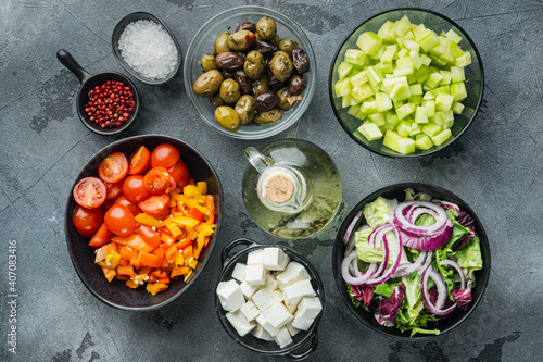 Ingredients for traditional greek salad. Tomatoes, onion, olives, feta cheese, on gray background, top view flat lay