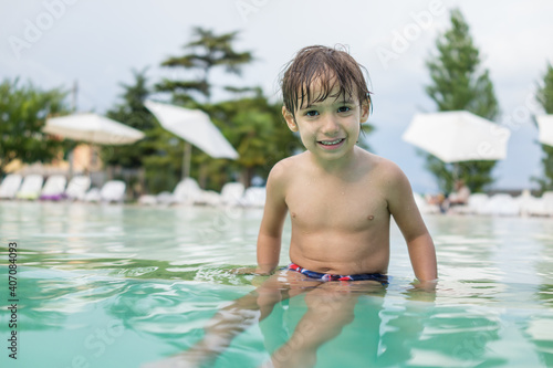 Young boy kid child splashing in swimming pool having fun leisure activity © Jasmin Merdan