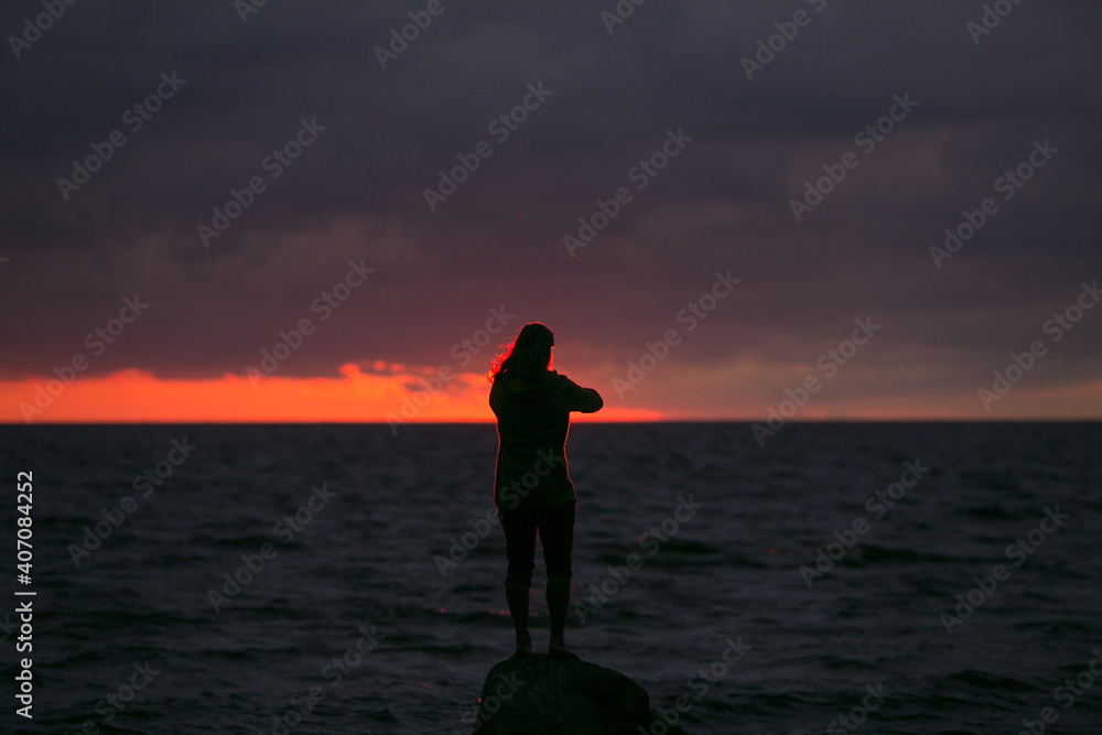 Fototapeta premium Man on the background of the sunset at sea.