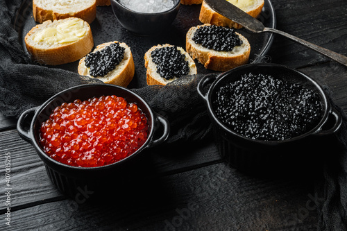 Canapes with black sturgeon and salmon fish caviar, on black wooden table background