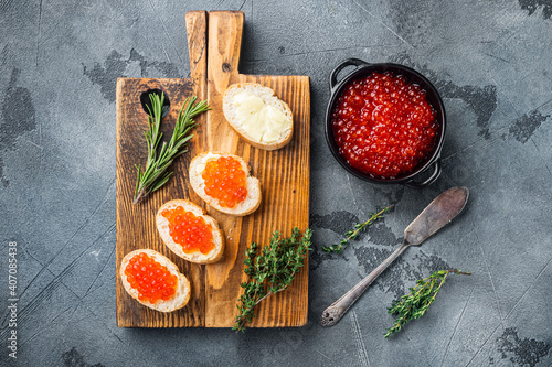 Canape with Red Salmon Caviar for New Year, on gray background, top view flat lay
