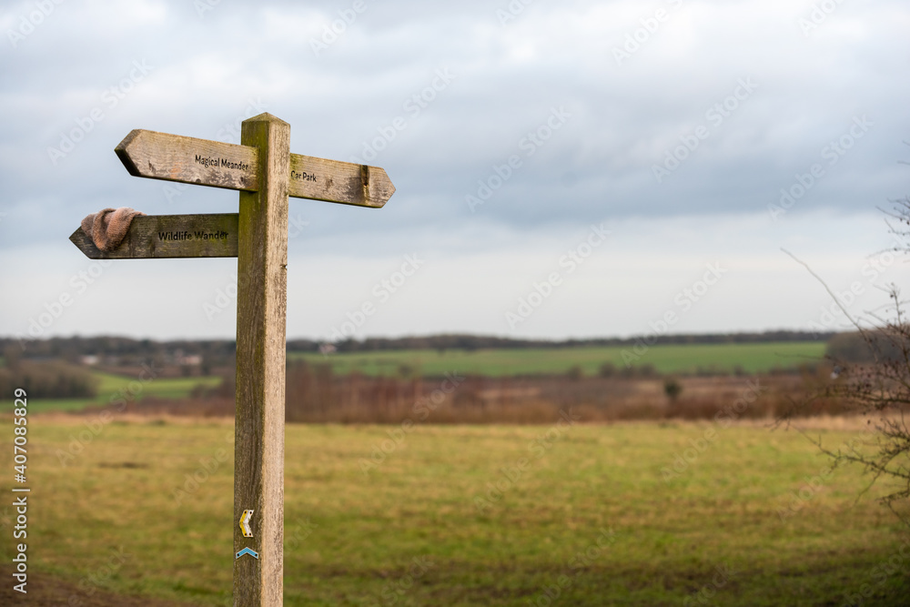 Wooden signpost outside on a public footpath through countryside with a lost item of clothing Wooden signpost outside on a public footpath through countryside with a lost item of clothing