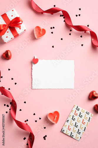 Valentines Day creative layout with blank paper card, gift box, red ribbon, confetti on pink background. Love, romance concept. © photoguns