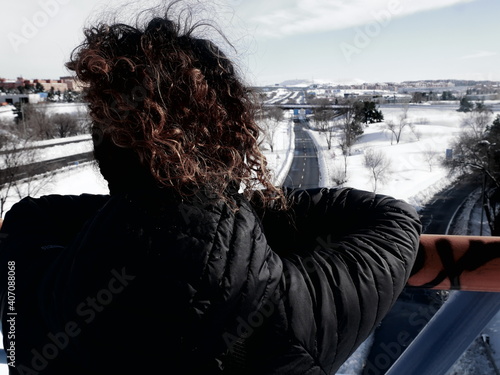 GIRL LOOKING AT SNOWY LANDSCAPA photo