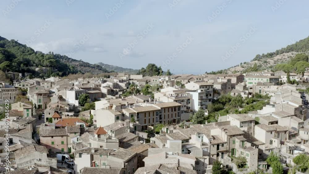 Old Mallorca village dron 4K video. Aerial view of historic houses, churches that stand on a mountain surrounded by mountain ranges with forests Old Mallorca village dron 4K video. Aerial view of historic houses, churches that stand on a mountain surrounded by mountain ranges with forests
