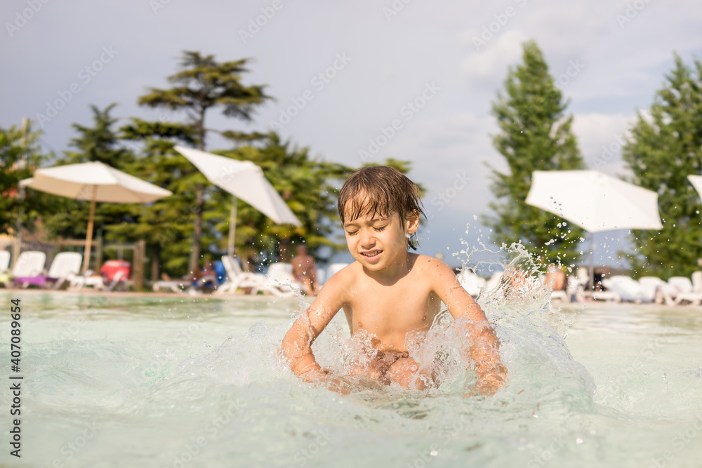 Cute little boy kid child splashing in swimming pool having fun leisure activity Cute little boy kid child splashing in swimming pool having fun leisure activity