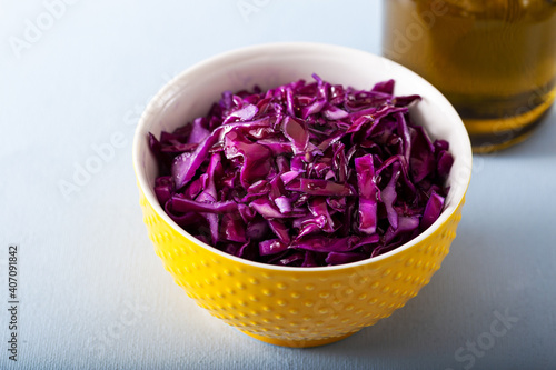 Fresh red cabbage in yellow bowl on table.