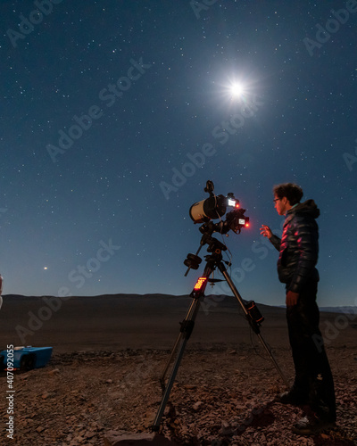 One astronomer man looking the night sky through an amateur telescope and taking photos to the Christmas Star rising over the horizon, an amazing and historical night view at Atacama Desert the Great 