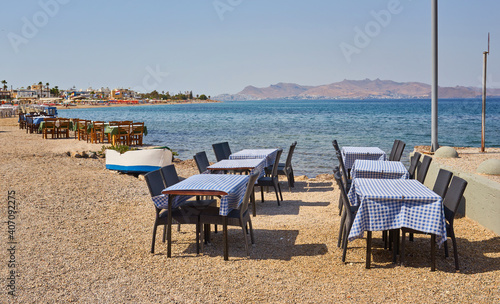 Greek beach with traditional blue tables and chairs © Ryzhkov Oleksandr