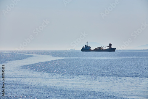 Cloudy horizon and Fog over the sea waves, natural background, cargo ship on the horizon