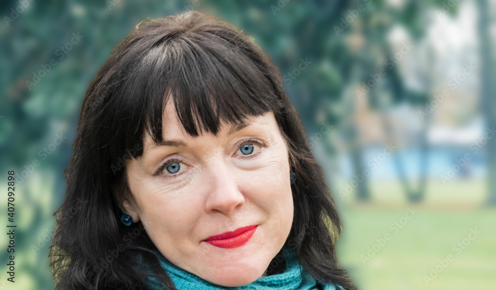 close-up portrait of woman, middle-aged 45-year-old brunette stands against the background of the park close-up portrait of woman, middle-aged 45-year-old brunette stands against the background of the park