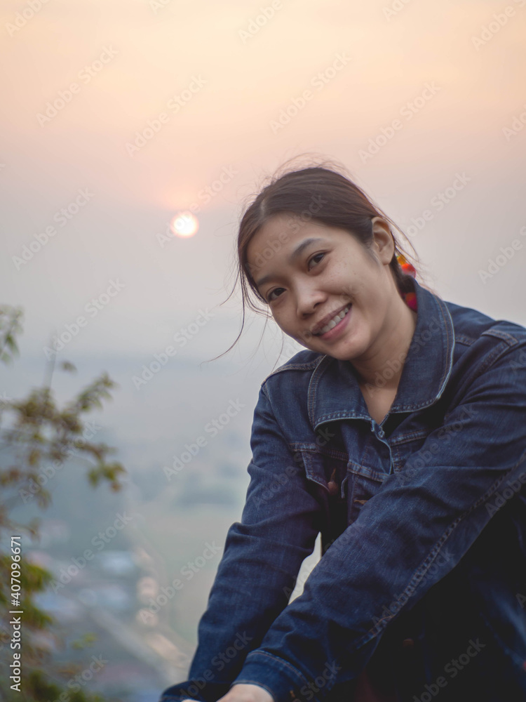 Woman wearing denim shirt against mountain background with morning sun Woman wearing denim shirt against mountain background with morning sun