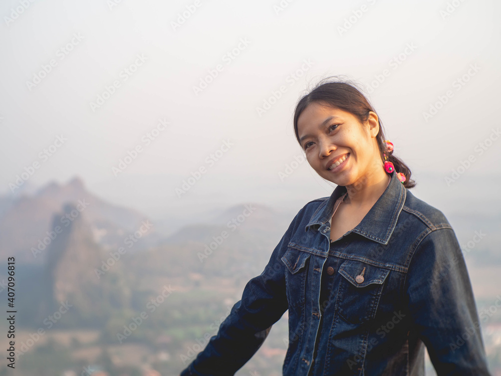 Woman wearing denim shirt with mountain background