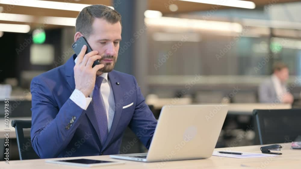 Middle Aged Businessman with Laptop Talking on Smartphone Middle Aged Businessman with Laptop Talking on Smartphone