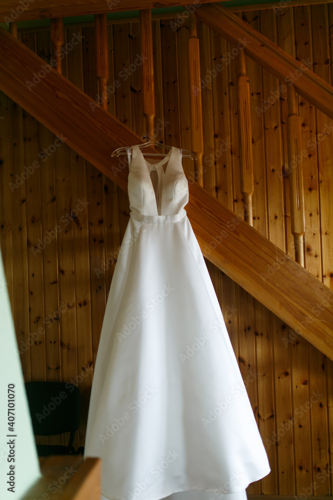 The wedding dress is hanging in the house.