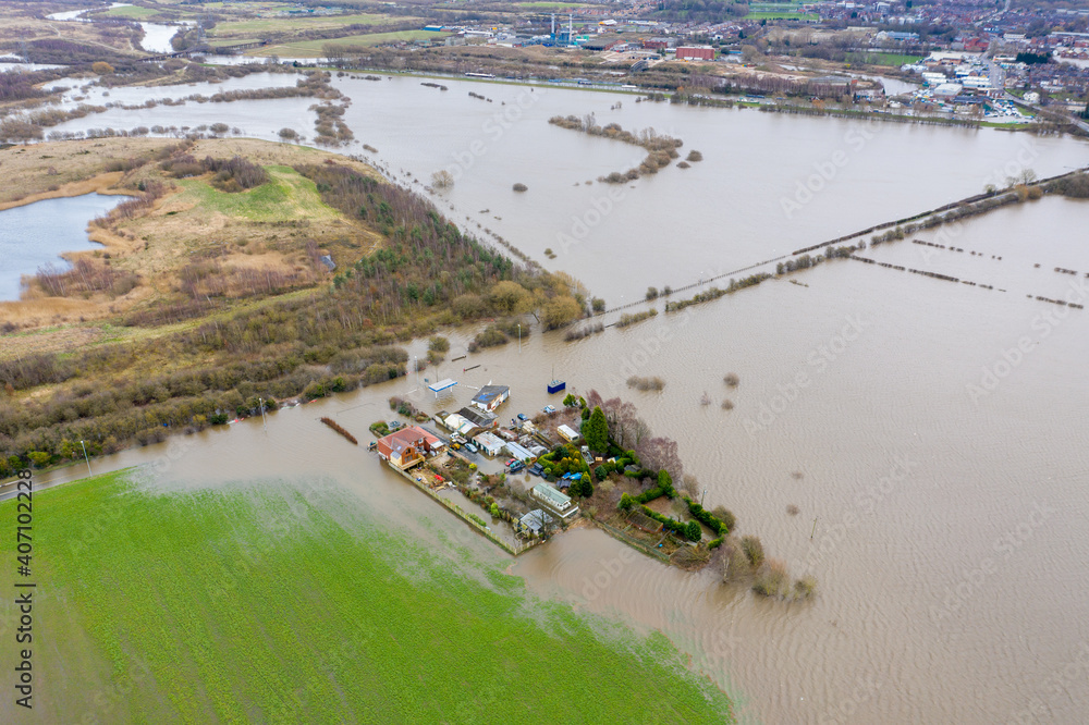 Aerial drone photo of the town of Allerton Bywater near Castleford in Leeds West Yorkshire showing the flooded fields and farm house from the River Aire during a large flood after a storm.