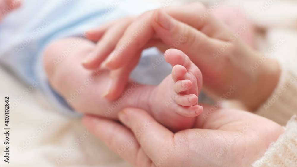 Closeup shot of little newborn baby feet in gentle mothers hands. Concept of family happiness and loving parents with little children Closeup shot of little newborn baby feet in gentle mothers hands. Concept of family happiness and loving parents with little children