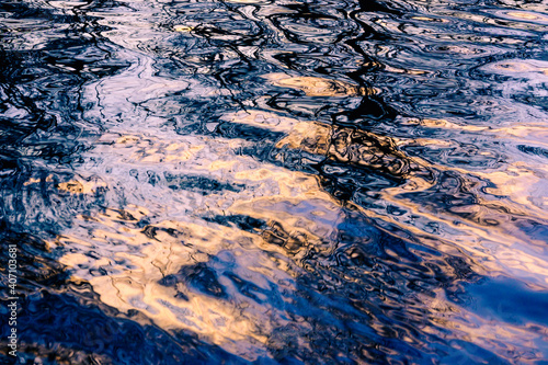 Water ripples with sky and cloud reflections