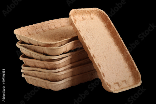 Biodegradable food trays made from pressed cardboard isolated on black background. Closeup