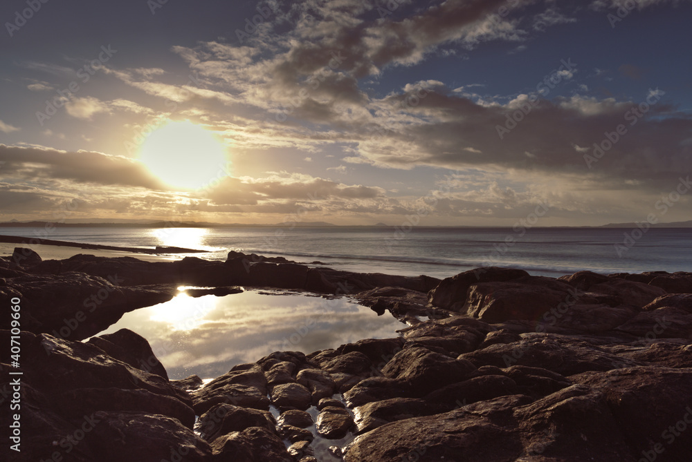 Obraz premium Sunset over rocky beach