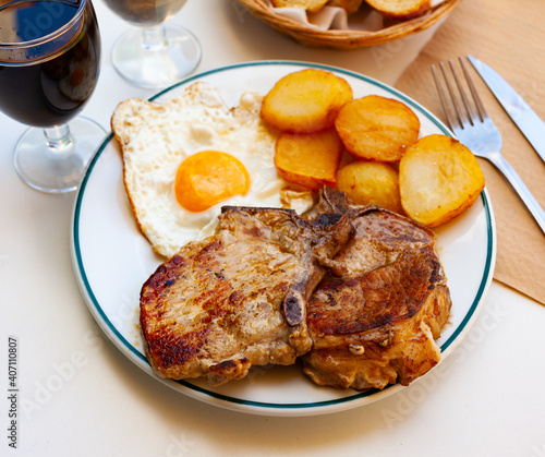 Plate with prepared food pork chop with potatoes and scrambled eggs