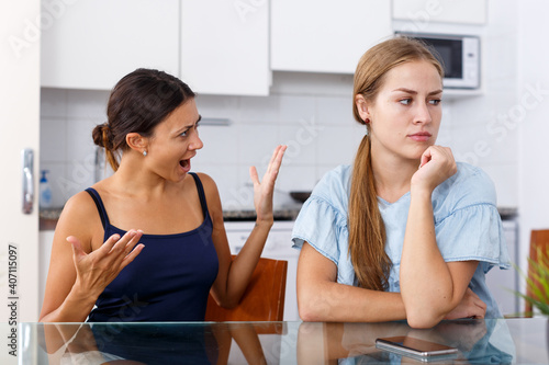 Portrait of upset young women discussing, quarrel at home kitchen indoor