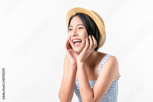Studio shot of cheerful beautiful Asian woman in blue color dress and wearing a hat and stand on white background.