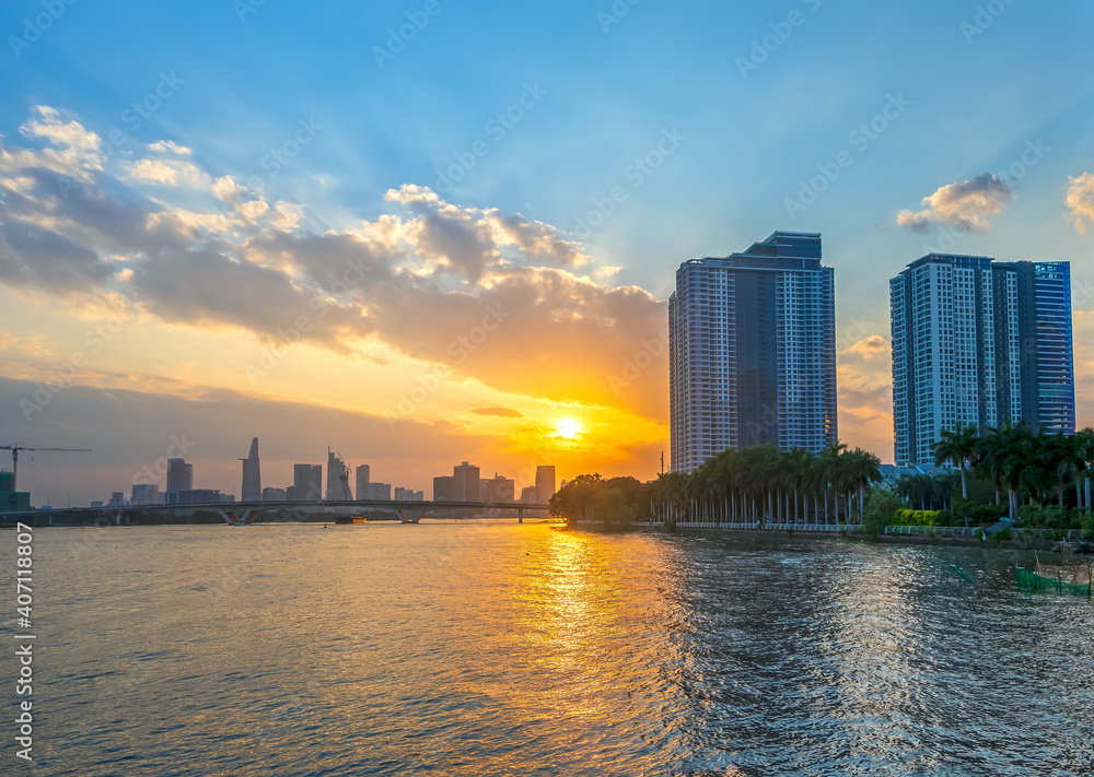  Sunset in urban areas along river with skyscrapers read shine by sky dramatic create beauty of urban development in Ho Chi Minh City, Vietnam